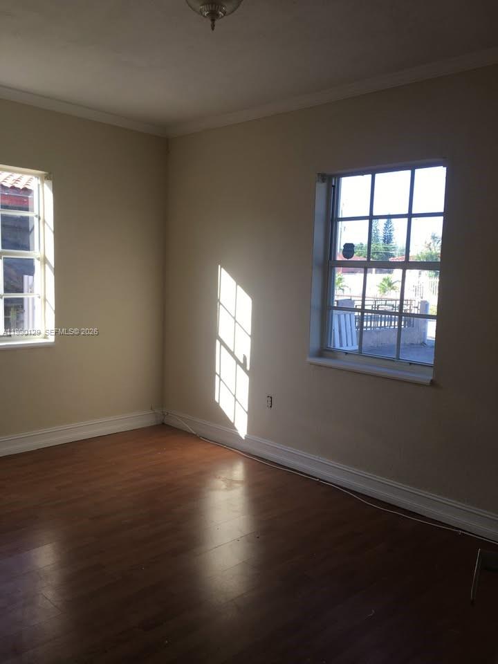 625 East 8th Court Hialeah, FL 33010 - Photo 8 of 18 an empty room with wooden floor and windows
