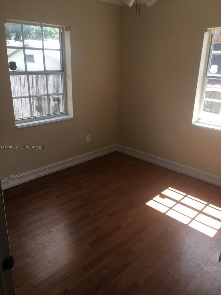 625 East 8th Court Hialeah, FL 33010 - Photo 9 of 18 an empty room with wooden floor and windows