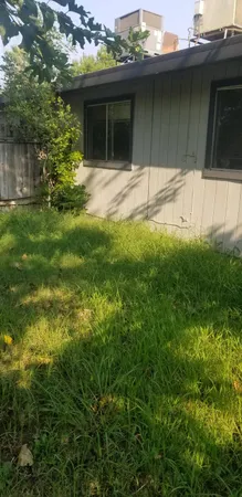 a view of backyard with wooden fence and trees