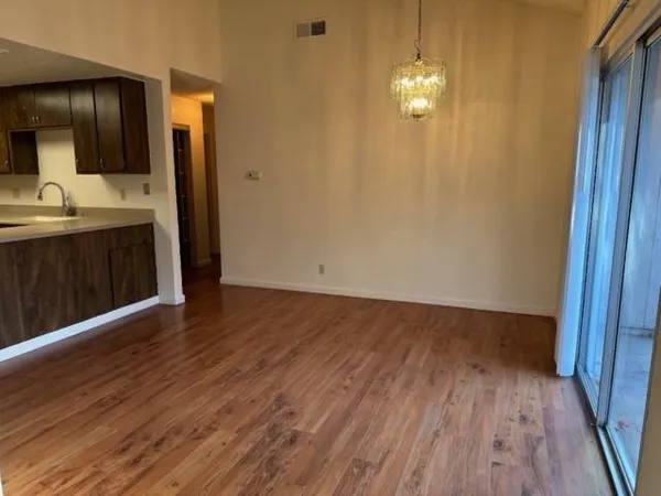 a view of a kitchen from the hallway with a sink and wooden floor