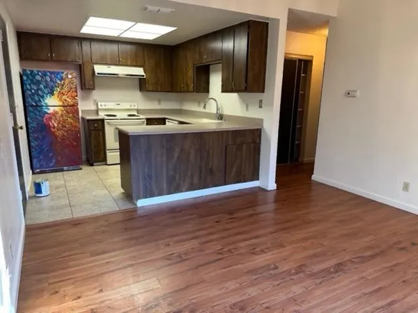 a kitchen with stainless steel appliances granite countertop a stove and a wooden floors