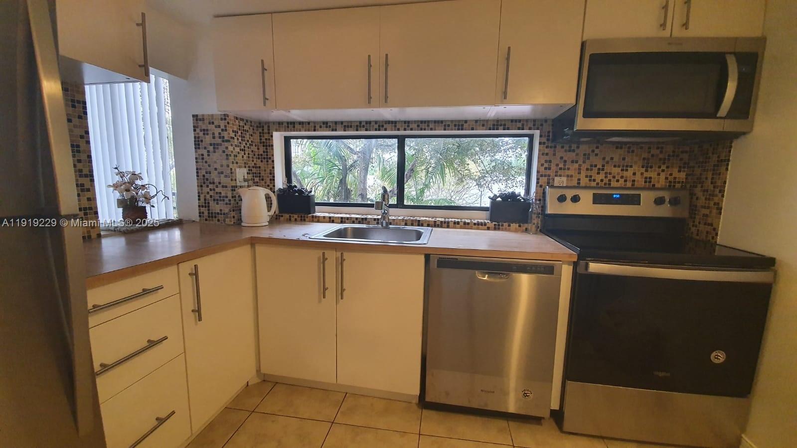 17021 North Bay Road, Unit 316 Sunny Isles Beach, FL 33160 - Photo 12 of 19 a kitchen with stainless steel appliances granite countertop a stove a sink and a microwave