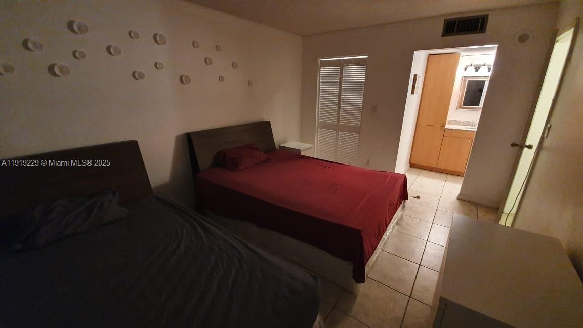 17021 North Bay Road, Unit 316 Sunny Isles Beach, FL 33160 - Photo 13 of 19 a bedroom with a bed and a mirror