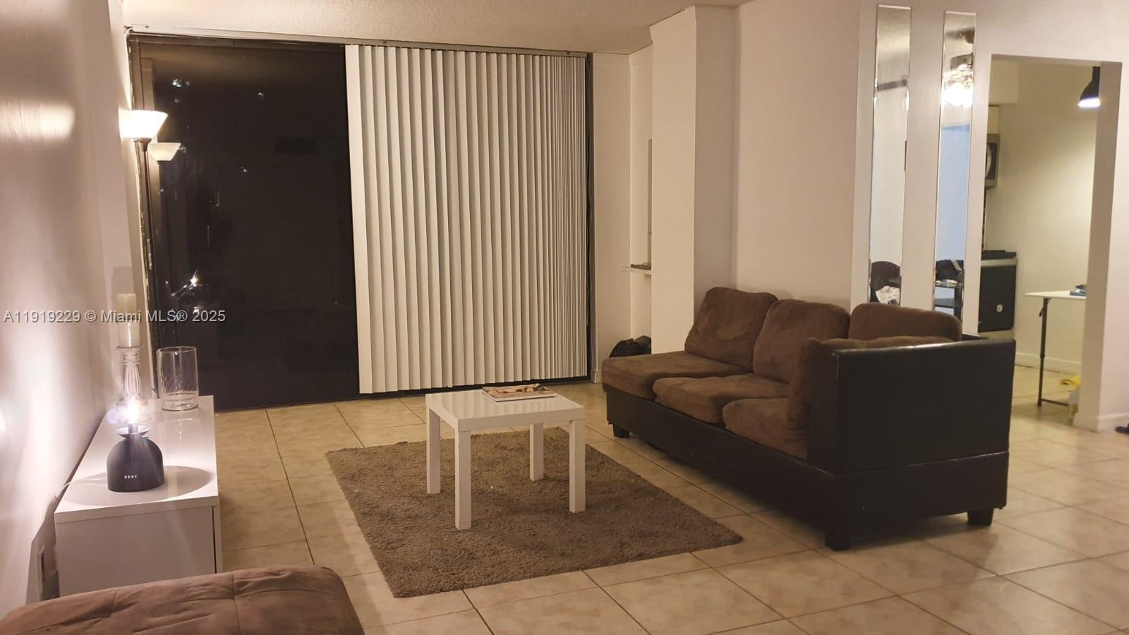 17021 North Bay Road, Unit 316 Sunny Isles Beach, FL 33160 - Photo 8 of 19 a living room with furniture and a lamp