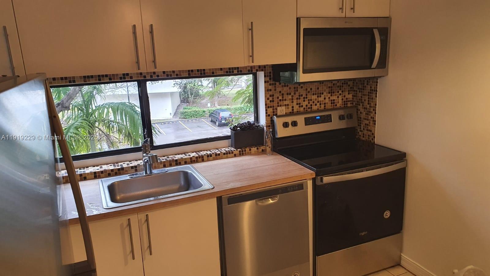 17021 North Bay Road, Unit 316 Sunny Isles Beach, FL 33160 - Photo 10 of 19 a kitchen with a stove and a microwave