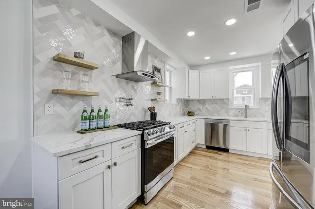 a kitchen with stainless steel appliances granite countertop a stove a sink and a refrigerator