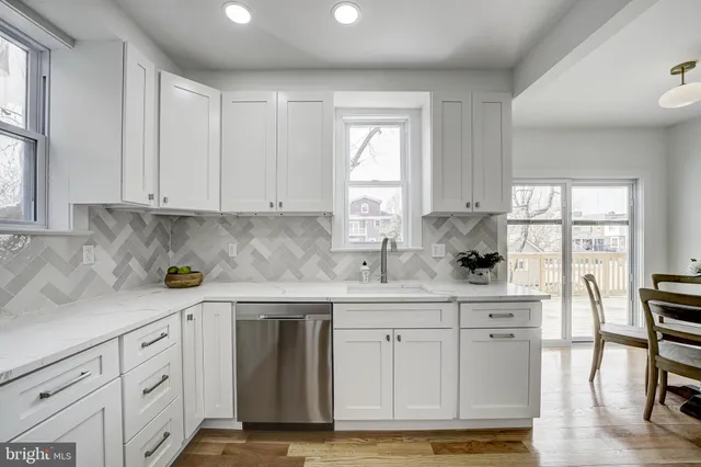 a kitchen with stainless steel appliances granite countertop a sink window and cabinets