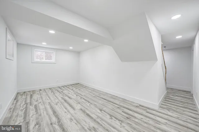 an empty room with wooden floor and entrance