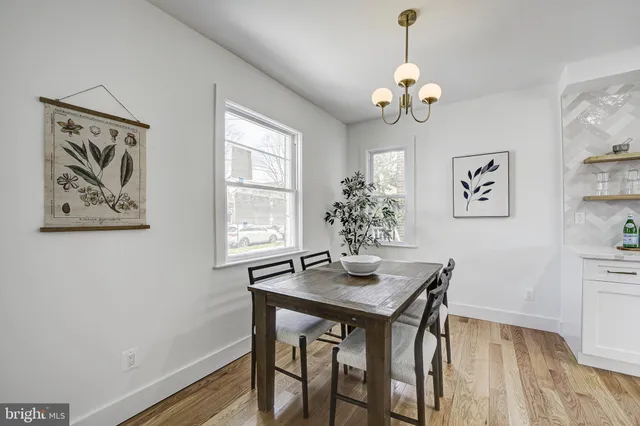 a dining room with wooden floor and a chandelier
