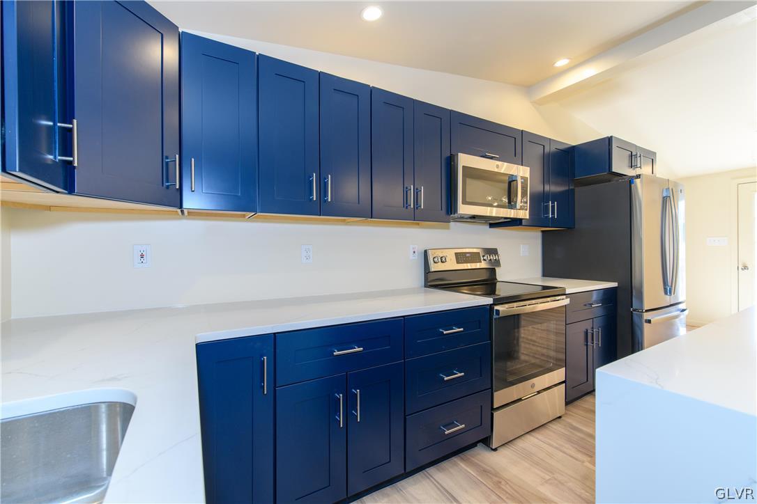 396 Swamp Road Wind Gap, PA 18091 - Photo 12 of 50 a kitchen with a refrigerator sink and wooden cabinets
