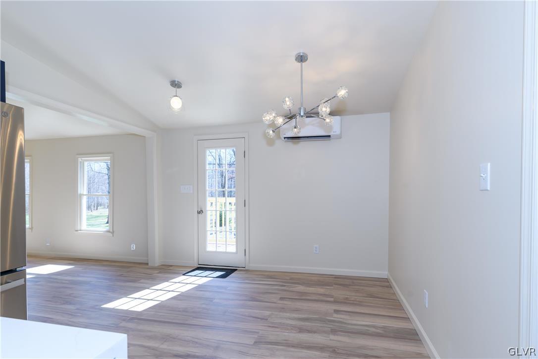 396 Swamp Road Wind Gap, PA 18091 - Photo 17 of 50 an empty room with wooden floor chandelier and windows