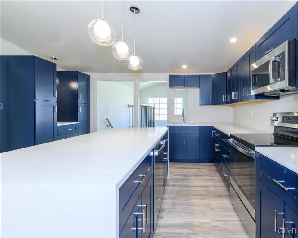 396 Swamp Road Wind Gap, PA 18091 - Photo 10 of 50 a kitchen with kitchen island granite countertop wooden cabinets and stainless steel appliances