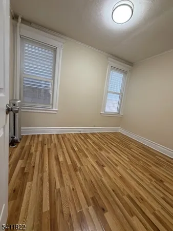 a view of a room with wooden floor and window