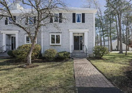 a view of a house with a yard covered in snow
