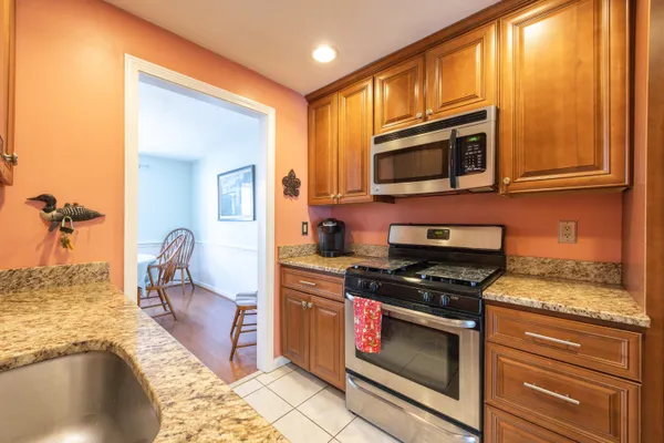 a kitchen with stainless steel appliances granite countertop a stove and a microwave