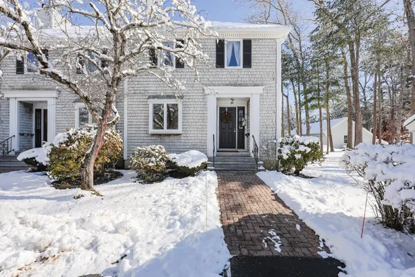 a view of a house with a yard covered in snow