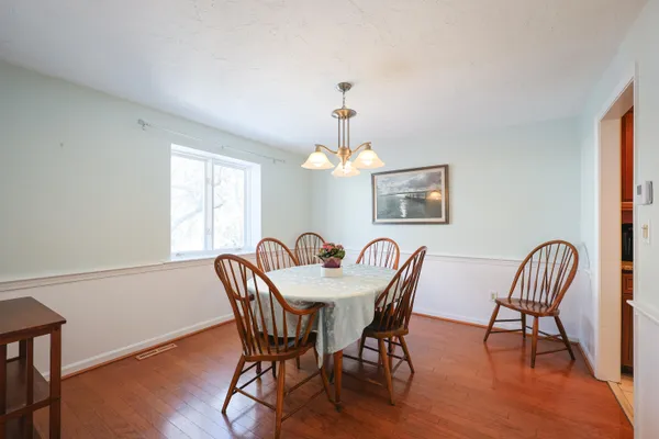 a dining room with furniture a chandelier and wooden floor