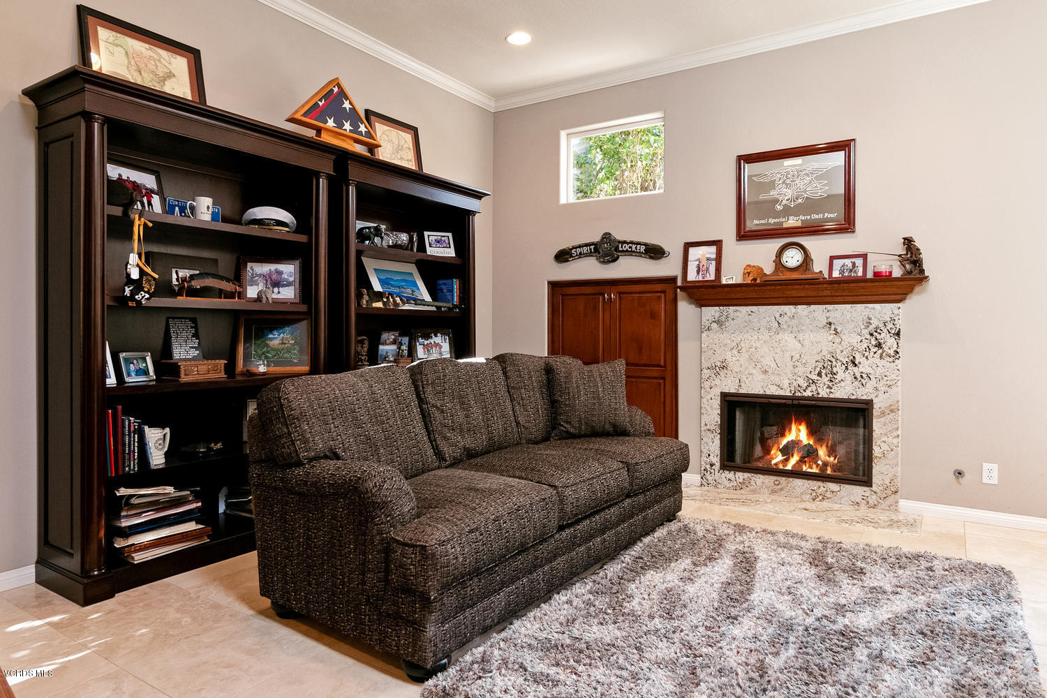 1121 Corte Riviera Camarillo, CA 93010 - Photo 10 of 35 a living room with furniture a bookshelf and a fireplace