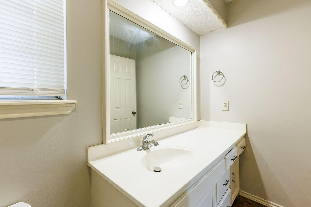 6411 York Drive, Unit B Lubbock, TX 79414 - Photo 22 of 28 a bathroom with a sink and a mirror