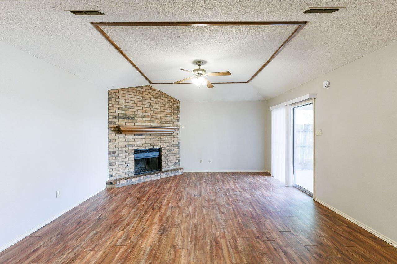 6411 York Drive, Unit B Lubbock, TX 79414 - Photo 5 of 28 a view of a livingroom with wooden floor fireplace and a window