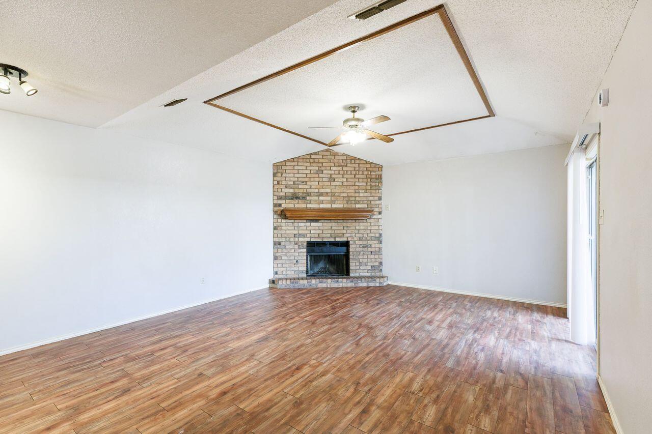 6411 York Drive, Unit B Lubbock, TX 79414 - Photo 6 of 28 a view of empty room with a fireplace and wooden floor