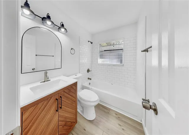 a bathroom with a granite countertop toilet sink and mirror