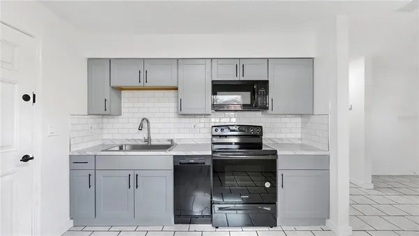 a kitchen with a sink a stove and cabinets