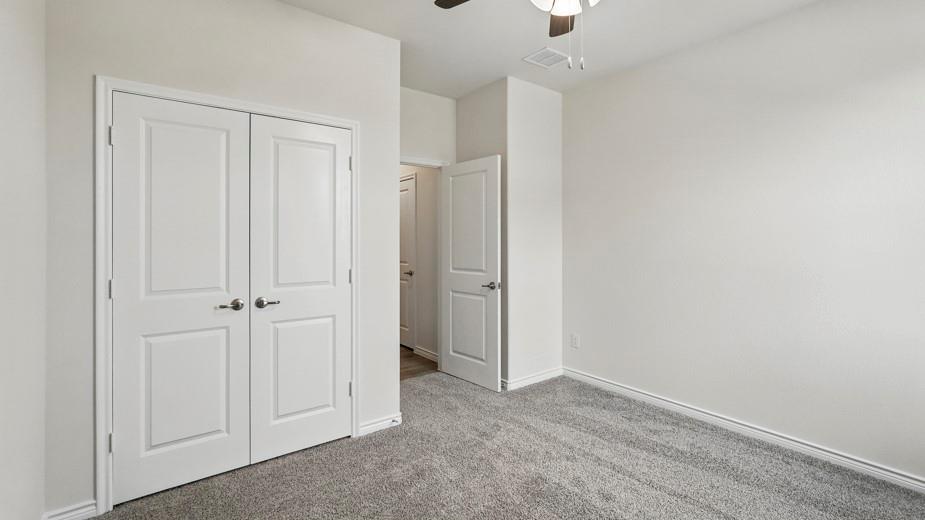 4162 Waldron Trail Forney, TX 75126 - Photo 26 of 29 Neutral-toned room featuring a ceiling fan, light gray carpeting, crisp white walls, white baseboards, and a double-door closet with paneling and brushed nickel hardware