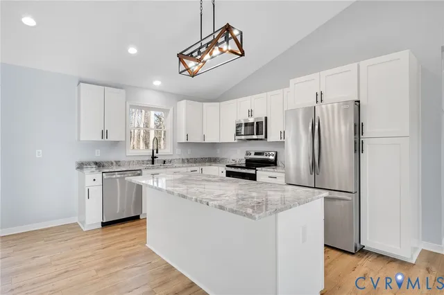 a kitchen with stainless steel appliances granite countertop a refrigerator a stove a sink and a microwave