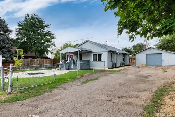 a front view of house with a garden and trees