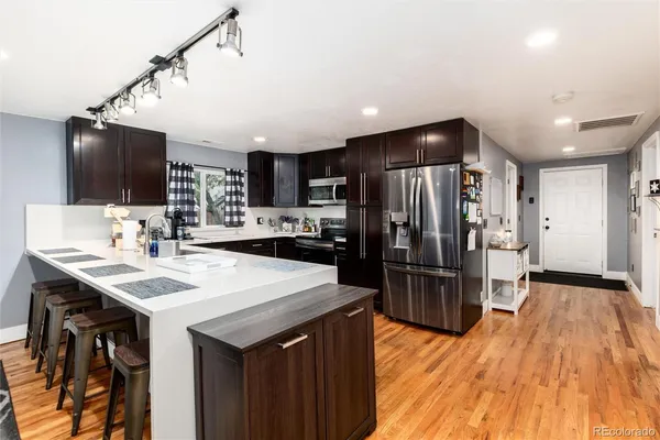 a kitchen with kitchen island a sink appliances and cabinets