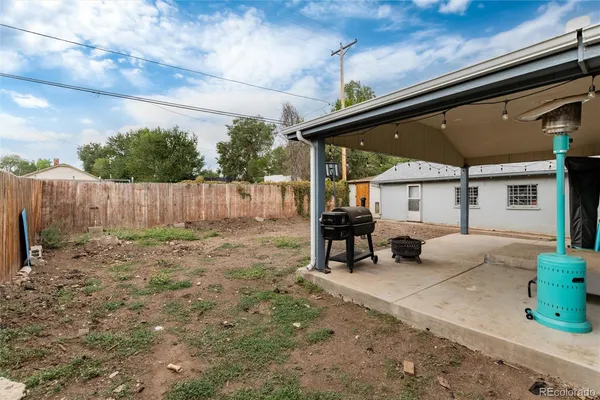 a view of backyard with wooden fence and a large tree