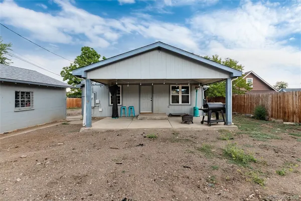 a view of a house with a yard and wooden fence