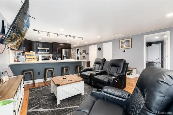 a living room with furniture and a wooden floor