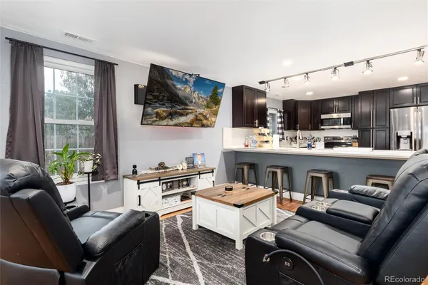 a living room with stainless steel appliances kitchen island granite countertop furniture and a large window