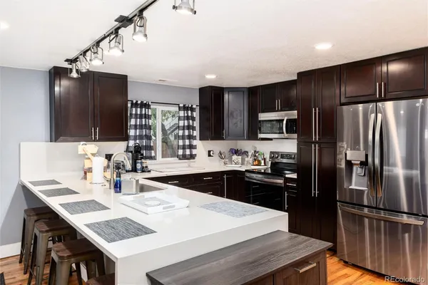 a kitchen with granite countertop a refrigerator and a sink