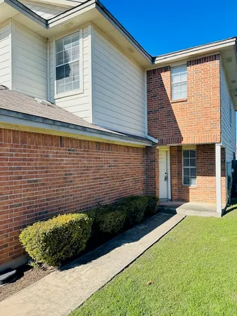 a view of a backyard with plants and large tree