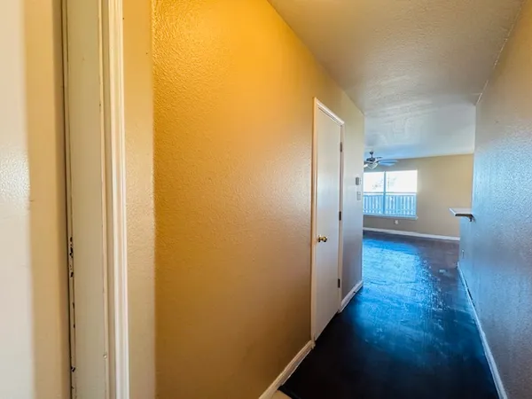 a view of a hallway with wooden floor
