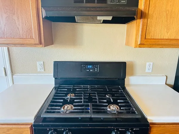 a kitchen with stove and cabinets
