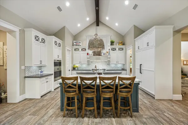 a kitchen with stainless steel appliances a dining table chairs and wooden floor