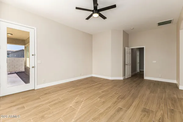 a view of an empty room with wooden floor and a window