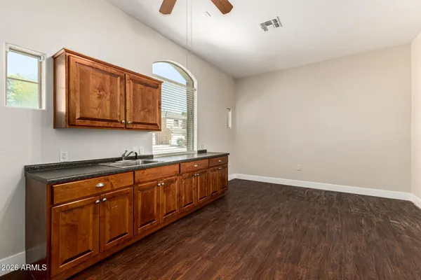 a kitchen with granite countertop wooden cabinets and a wooden floor