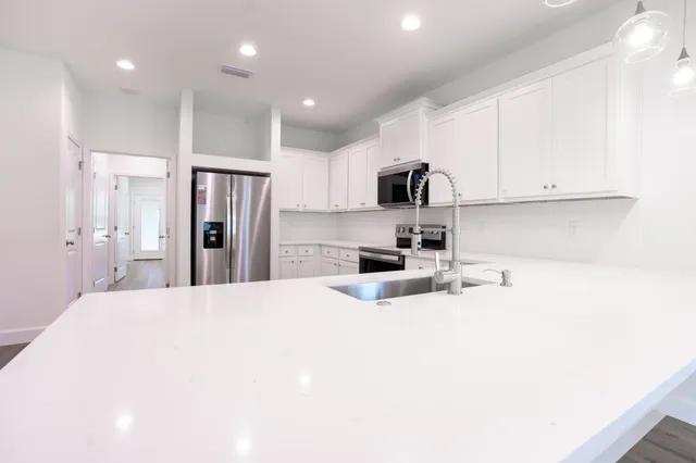 a kitchen with stainless steel appliances a refrigerator stove microwave and cabinets