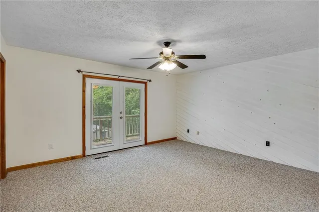 a view of a big room with chandelier fan and windows