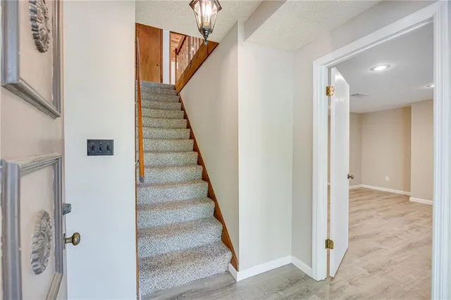 a view of staircase with wooden floor and white walls