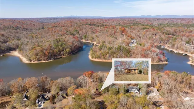 an aerial view of a house with a yard and lake view