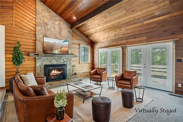 a living room with furniture a fireplace and a floor to ceiling window