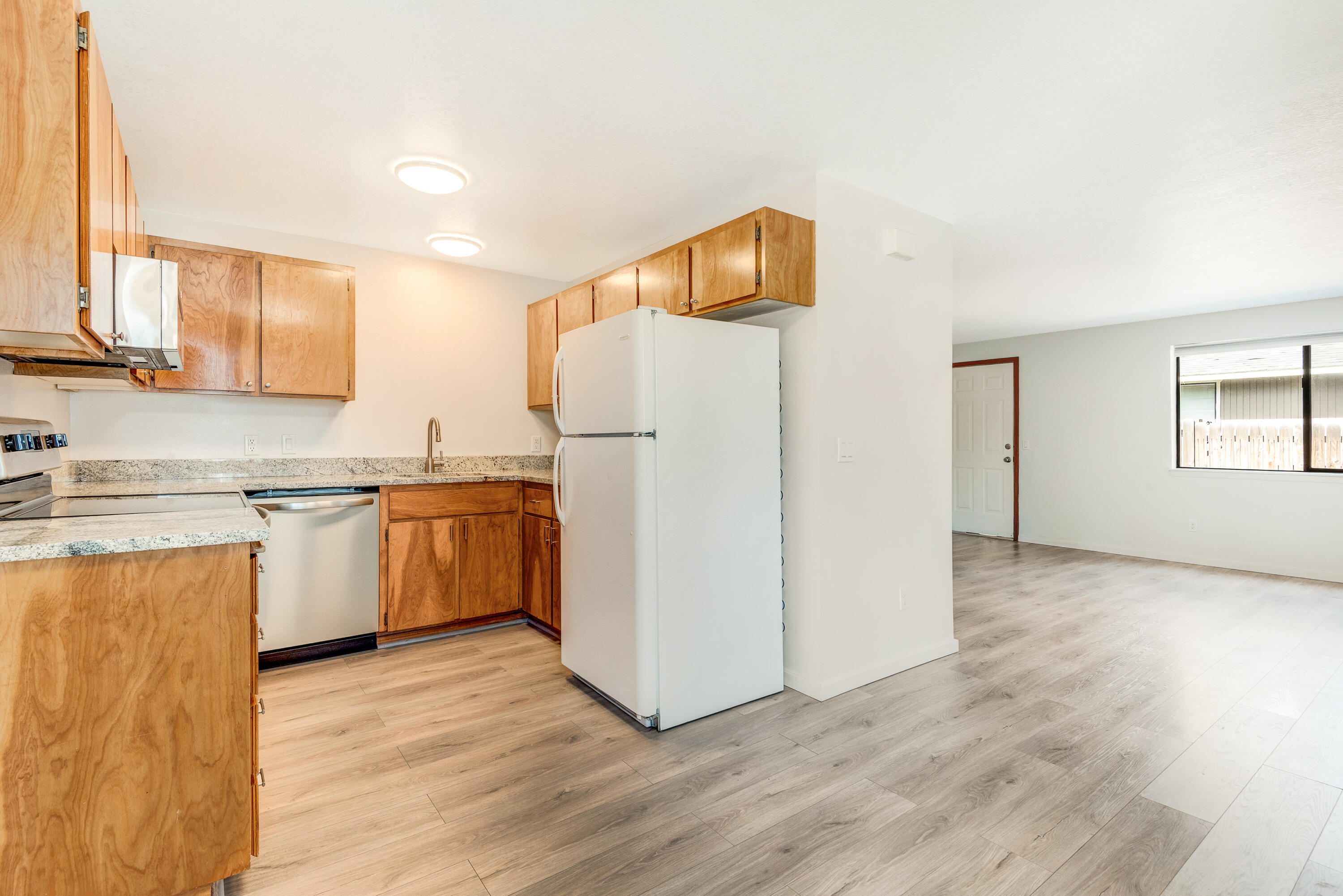 1916 Northeast Wichita Way Bend, OR 97701 - Photo 10 of 38 a kitchen with a sink a refrigerator and white cabinets