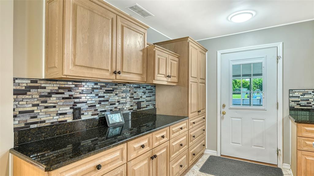3818 Gocio Rd Extention Sarasota, FL 34235 - Photo 16 of 65 a kitchen with granite countertop white cabinets and stainless steel appliances