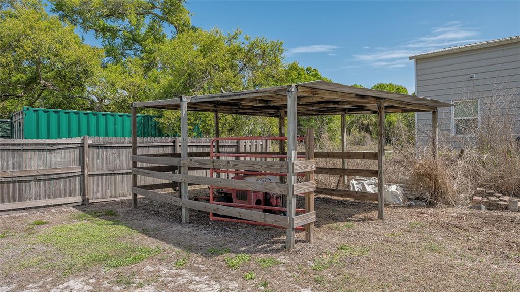 3818 Gocio Rd Extention Sarasota, FL 34235 - Photo 56 of 65 a view of a backyard with table and chairs under an umbrella with wooden fence